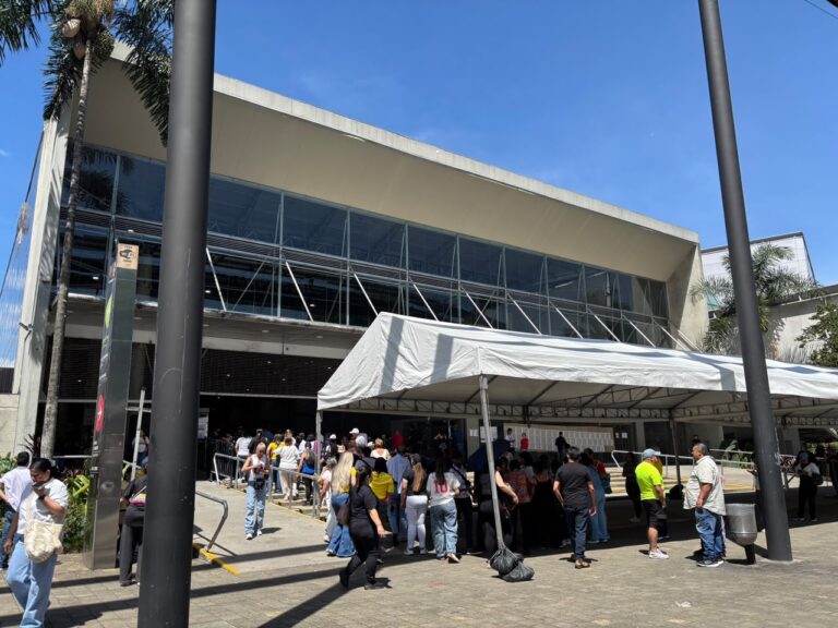 Decenas de votantes hacen fila para entrar a votar, mientras sus acompañantes los esperan afuera de Plaza Mayor.